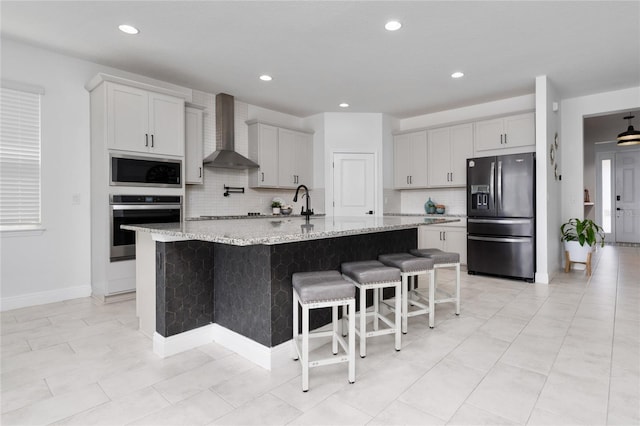 2591 Seagirt Way, Clermont, FL 34711 - kitchen with stainless steel appliances, wall chimney exhaust hood, backsplash, a kitchen bar, and recessed lighting