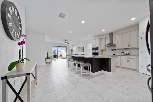2591 Seagirt Way, Clermont, FL 34711 - kitchen featuring wall chimney range hood, tasteful backsplash, recessed lighting, a center island with sink, and a ceiling fan