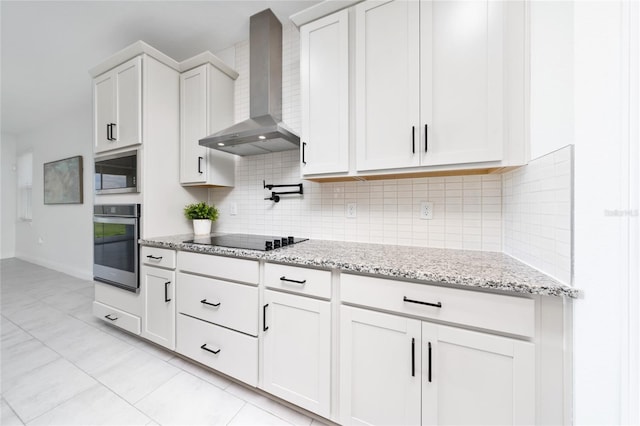 2591 Seagirt Way, Clermont, FL 34711 - kitchen featuring wall chimney exhaust hood, appliances with stainless steel finishes, tasteful backsplash, light stone countertops, and white cabinets