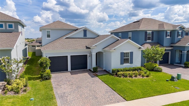 2591 Seagirt Way, Clermont, FL 34711 - view of front of home featuring stucco siding, decorative driveway, an attached garage, and a front yard