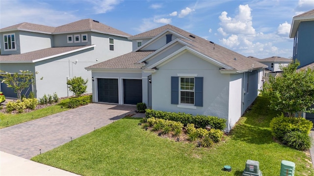 2591 Seagirt Way, Clermont, FL 34711 - view of front of home featuring stucco siding, an attached garage, a front yard, and decorative driveway
