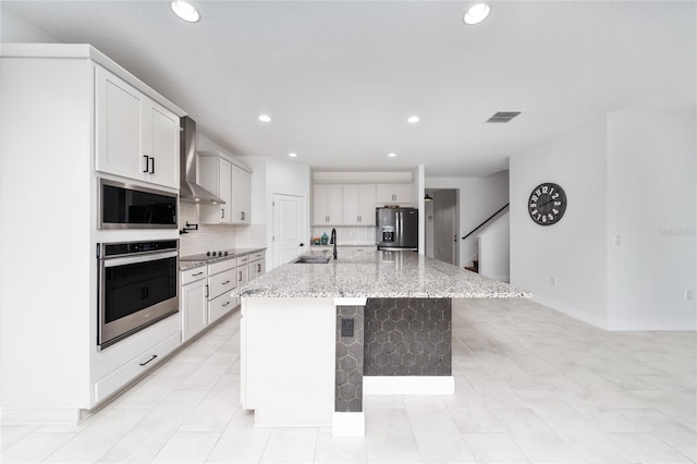 2591 Seagirt Way, Clermont, FL 34711 - kitchen featuring stainless steel appliances, wall chimney exhaust hood, recessed lighting, backsplash, and white cabinets