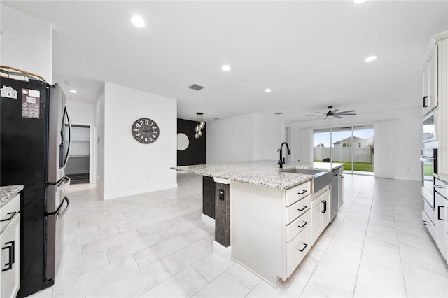 2591 Seagirt Way, Clermont, FL 34711 - kitchen with stainless steel appliances, a ceiling fan, an island with sink, light stone counters, and recessed lighting