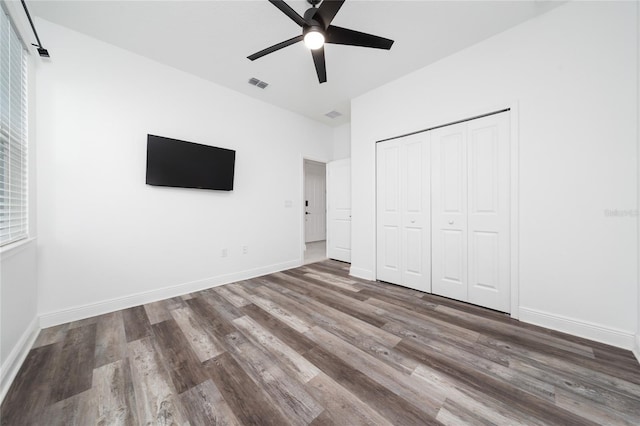 2591 Seagirt Way, Clermont, FL 34711 - unfurnished bedroom featuring wood finished floors, a closet, ceiling fan, and multiple windows
