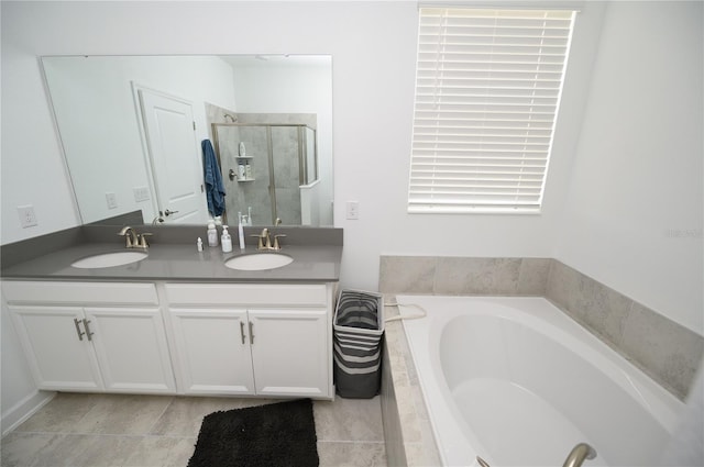 full bathroom featuring a stall shower, a bath, and double vanity