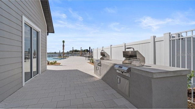 view of patio with area for grilling and fence