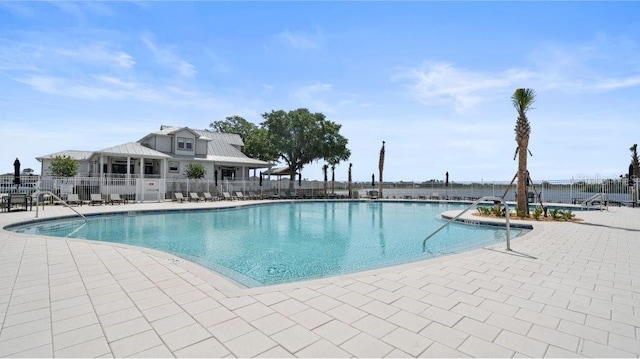 community pool featuring fence and a patio