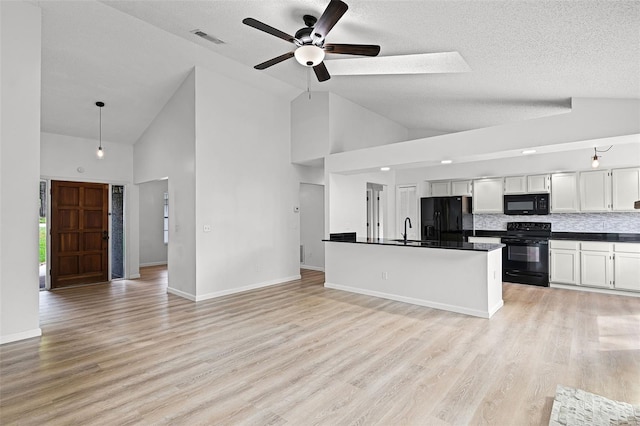 kitchen featuring black appliances, dark countertops, high vaulted ceiling, a sink, and ceiling fan