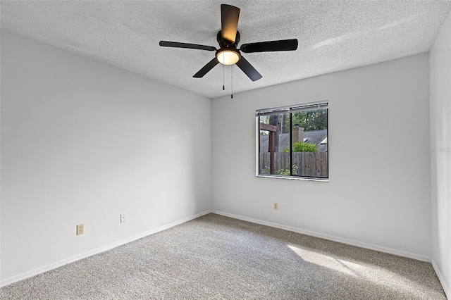 spare room featuring a textured ceiling, carpet, ceiling fan, and baseboards