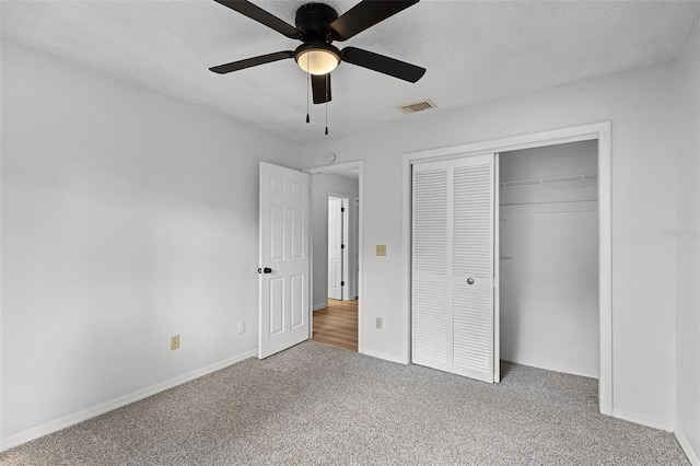 unfurnished bedroom featuring carpet, a textured ceiling, a closet, and baseboards