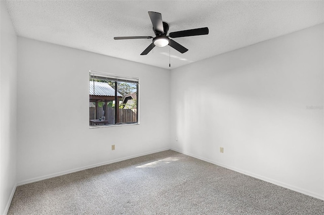unfurnished room with ceiling fan, a textured ceiling, carpet floors, and baseboards