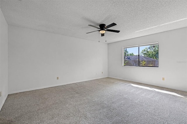 carpeted empty room with a ceiling fan, a textured ceiling, and baseboards