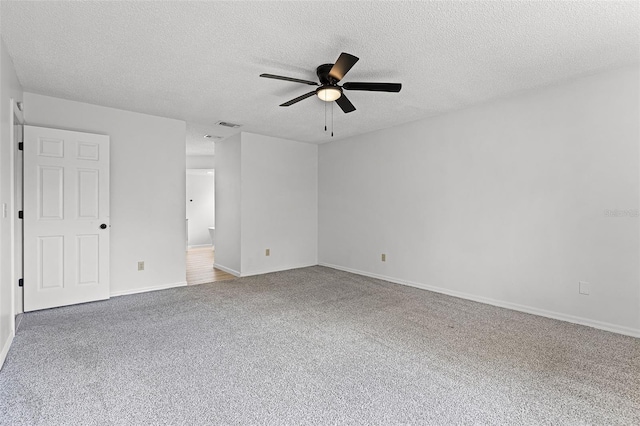 unfurnished room with a ceiling fan, carpet flooring, a textured ceiling, and baseboards