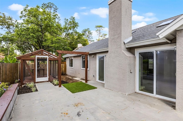 back of property featuring a chimney, a patio area, a fenced backyard, a shingled roof, and stucco siding