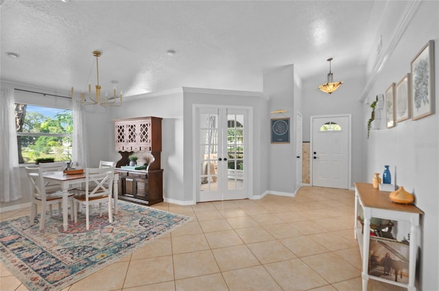tiled foyer featuring a chandelier, french doors, baseboards, and a textured ceiling