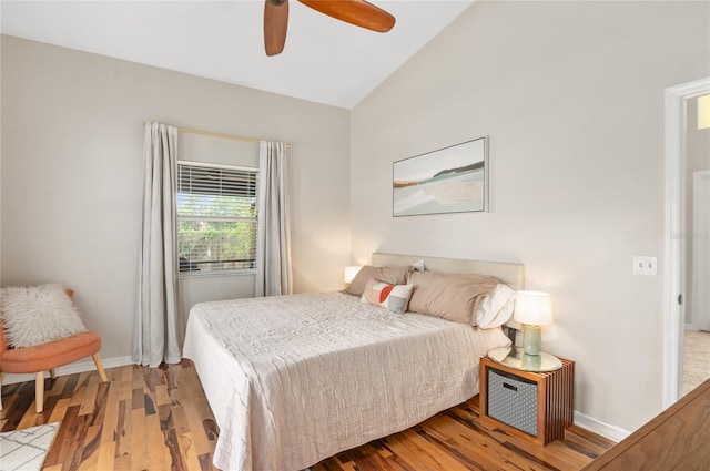 bedroom with vaulted ceiling, baseboards, wood finished floors, and a ceiling fan