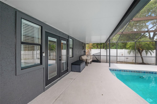 view of pool featuring french doors, a patio area, fence, and glass enclosure