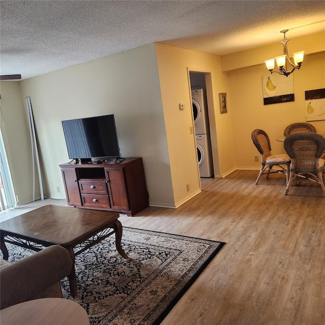 434 Windmeadows St Unit 434, Altamonte Springs, FL 32701 - living area with estacked washer and dryer, a chandelier, light wood-style floors, a textured ceiling, and baseboards