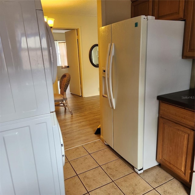 434 Windmeadows St Unit 434, Altamonte Springs, FL 32701 - kitchen with white fridge with ice dispenser, light tile patterned floors, dark countertops, and brown cabinetry
