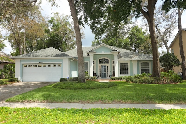 4201 Old Trafford Way, Orlando, FL 32810 - view of front facade featuring a garage, driveway, stucco siding, a front yard, and roof with shingles