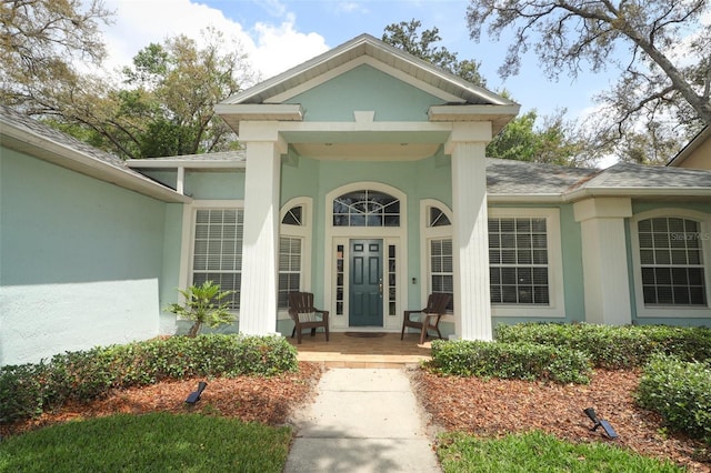 4201 Old Trafford Way, Orlando, FL 32810 - property entrance with a porch, a shingled roof, and stucco siding