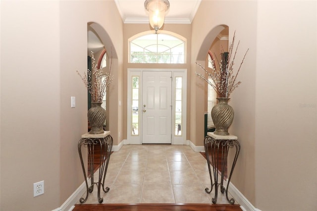 4201 Old Trafford Way, Orlando, FL 32810 - foyer entrance with light tile patterned floors, baseboards, crown molding, and arched walkways