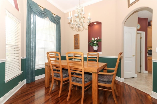 4201 Old Trafford Way, Orlando, FL 32810 - dining area with arched walkways, a chandelier, plenty of natural light, light wood-style floors, and crown molding