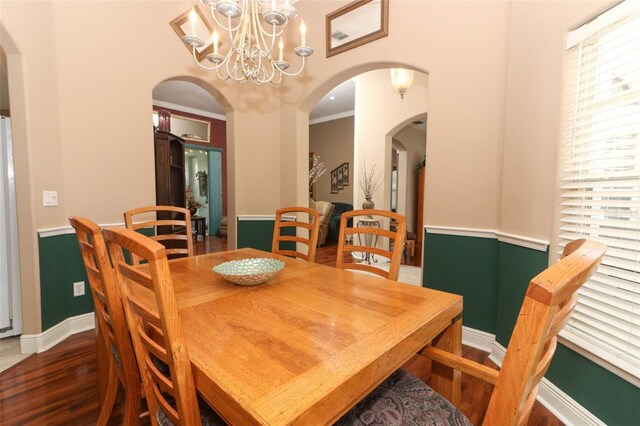 4201 Old Trafford Way, Orlando, FL 32810 - dining space featuring wood finished floors, arched walkways, a chandelier, baseboards, and ornamental molding