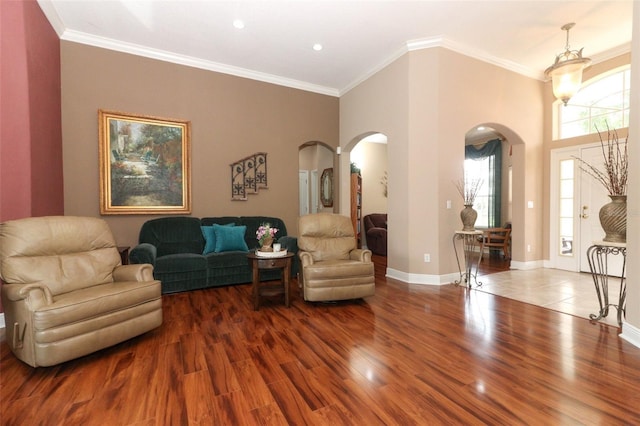 4201 Old Trafford Way, Orlando, FL 32810 - living room with arched walkways, wood finished floors, ornamental molding, baseboards, and recessed lighting