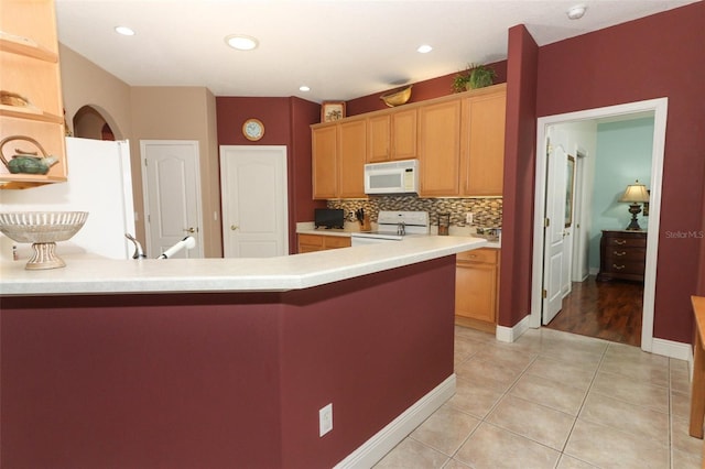 4201 Old Trafford Way, Orlando, FL 32810 - kitchen with white appliances, light tile patterned floors, a peninsula, light countertops, and backsplash
