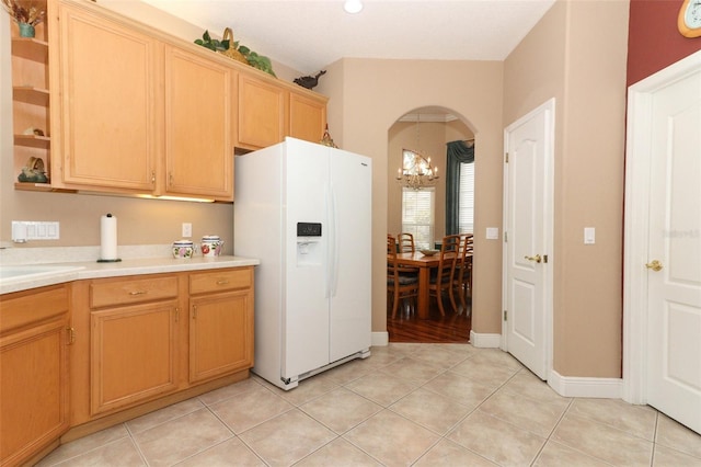 4201 Old Trafford Way, Orlando, FL 32810 - kitchen featuring white fridge with ice dispenser, arched walkways, light countertops, open shelves, and a chandelier