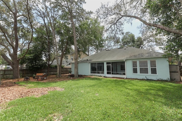 4201 Old Trafford Way, Orlando, FL 32810 - back of property with an outdoor fire pit, a sunroom, roof with shingles, and stucco siding