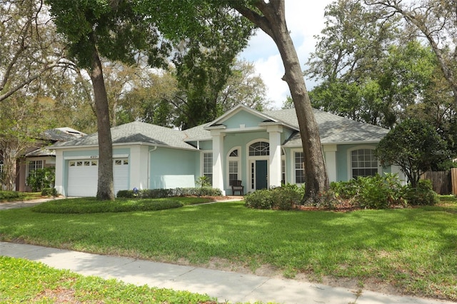 4201 Old Trafford Way, Orlando, FL 32810 - view of front facade with a garage, stucco siding, and roof with shingles