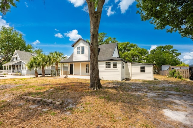 712 Maryland Ave, Saint Cloud, FL 34769 - rear view of house with a porch, fence, and roof with shingles