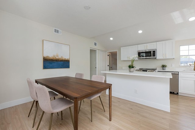 712 Maryland Ave, Saint Cloud, FL 34769 - dining area with light wood-style flooring, vaulted ceiling, baseboards, and recessed lighting