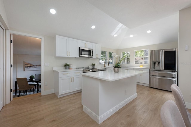 712 Maryland Ave, Saint Cloud, FL 34769 - kitchen with stainless steel appliances, white cabinets, light wood-style floors, light countertops, and lofted ceiling