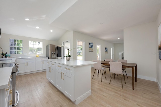 712 Maryland Ave, Saint Cloud, FL 34769 - kitchen with stainless steel appliances, light wood-style flooring, a center island, white cabinets, and light countertops