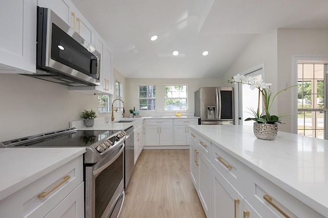 712 Maryland Ave, Saint Cloud, FL 34769 - kitchen featuring stainless steel appliances, recessed lighting, white cabinets, lofted ceiling, and a sink