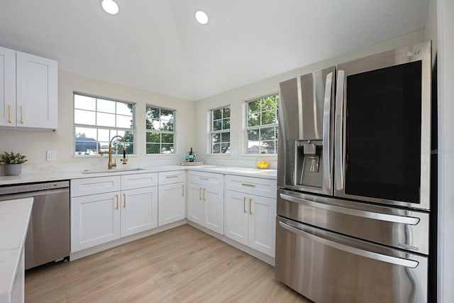 712 Maryland Ave, Saint Cloud, FL 34769 - kitchen with appliances with stainless steel finishes, a sink, light countertops, white cabinets, and light wood-style floors
