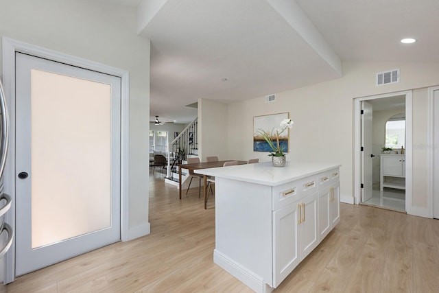 712 Maryland Ave, Saint Cloud, FL 34769 - kitchen featuring white cabinetry, light wood finished floors, plenty of natural light, light countertops, and recessed lighting