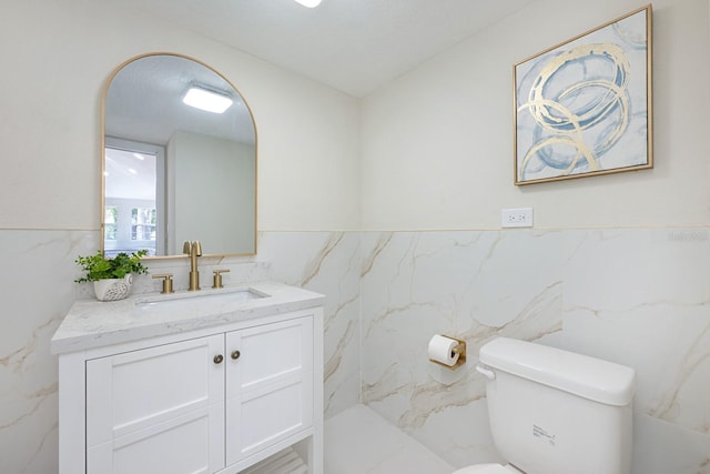 712 Maryland Ave, Saint Cloud, FL 34769 - bathroom featuring tile walls, toilet, vanity, and wainscoting