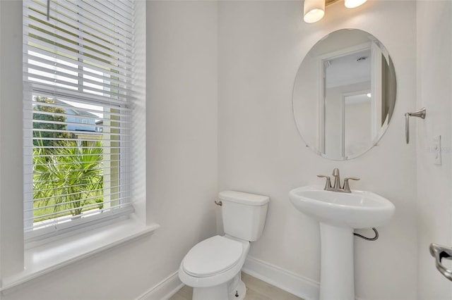 13913 Hahn Ln, Orlando, FL 32827 - bathroom featuring baseboards, healthy amount of natural light, toilet, and a sink