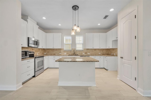 13913 Hahn Ln, Orlando, FL 32827 - kitchen featuring stainless steel appliances, light stone countertops, tasteful backsplash, white cabinets, and recessed lighting