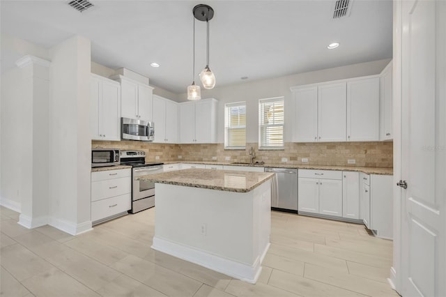 13913 Hahn Ln, Orlando, FL 32827 - kitchen with appliances with stainless steel finishes, tasteful backsplash, a sink, white cabinetry, and recessed lighting