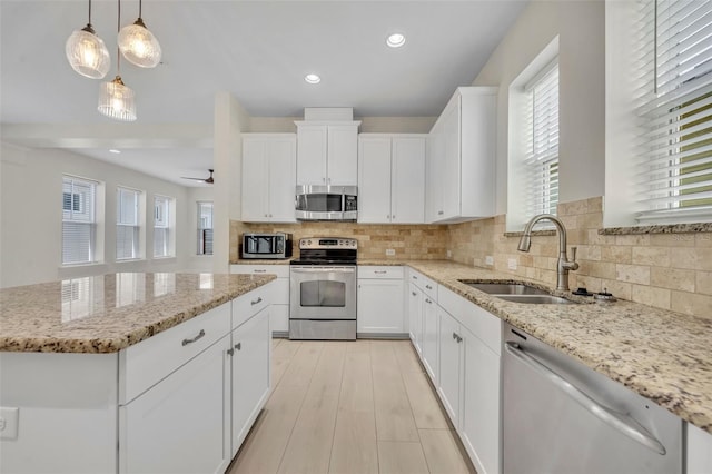13913 Hahn Ln, Orlando, FL 32827 - kitchen featuring stainless steel appliances, a sink, decorative backsplash, light stone countertops, and recessed lighting