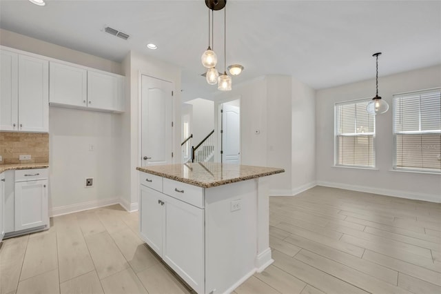 13913 Hahn Ln, Orlando, FL 32827 - kitchen with light wood-style floors, baseboards, light stone counters, and recessed lighting