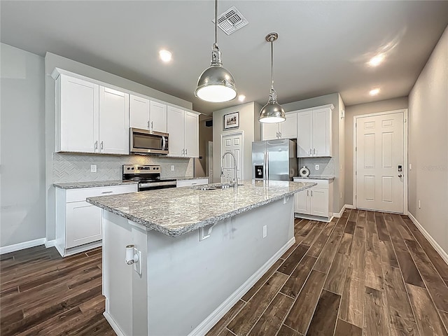 kitchen featuring stainless steel appliances, a sink, dark wood finished floors, baseboards, and recessed lighting