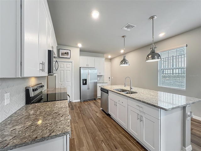 kitchen with appliances with stainless steel finishes, a sink, dark wood-style flooring, white cabinets, and recessed lighting
