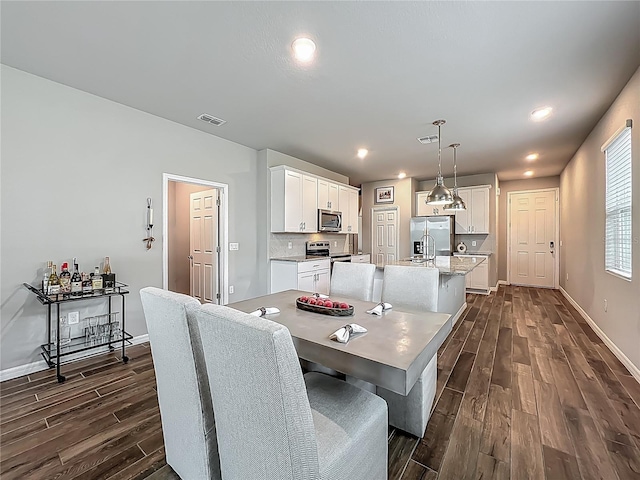 dining room featuring dark wood-style flooring, baseboards, and recessed lighting
