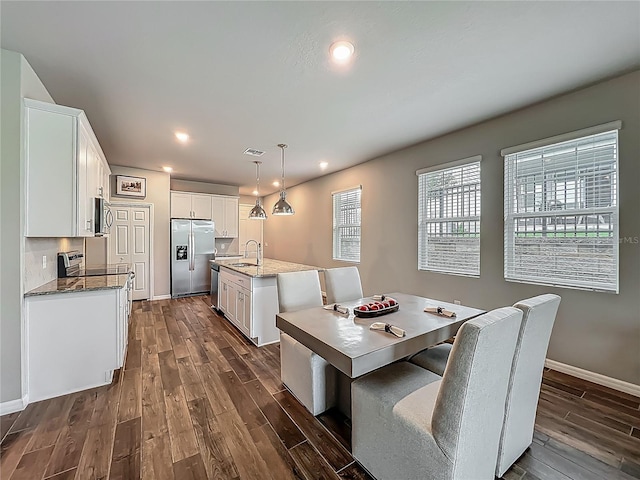 dining area with dark wood-type flooring, baseboards, and recessed lighting